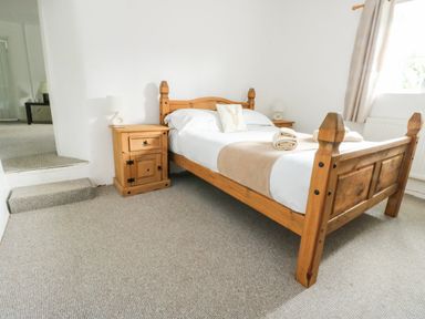 A bedroom with a bed and nightstand at Pen Bonc Llanddaniel Near Gaerwen