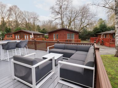 A deck area with seating and tables at Unique Luxury Lodge 1 Langdale, White Cross Bay near Windermere
