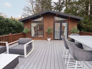 An outdoor seating area with a wooden cabin at Unique Luxury Lodge 1 Langdale, White Cross Bay near Windermere