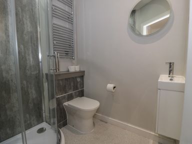 A bathroom with a corner shower cubicle toilet sink mirror and towel radiator at Luxury Lodge 69 in Dyserth
