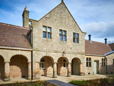 An exterior view of a stone building with arched doorways and windows at The Hayloft in Humshaugh