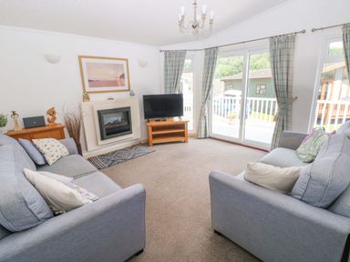 A living room with a sofa and television at Serenity in Kilgetty