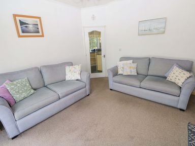 A living room with two sofas and a door at Serenity in Kilgetty