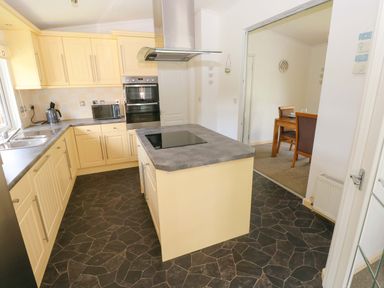 A kitchen with cabinets and appliances at Serenity in Kilgetty