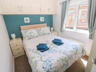 A bedroom with a bed and bedside table at Serenity in Kilgetty