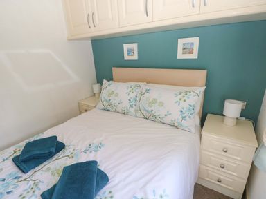 A bedroom with a bed and bedside drawers at Serenity in Kilgetty