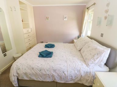 A bedroom with a bed and bedside table at Serenity in Kilgetty