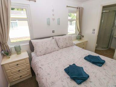 A bedroom with a bed and towels at Serenity in Kilgetty