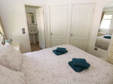 A bedroom with bed and towels on top at Serenity in Kilgetty