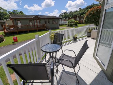 A patio with chairs and a table at Serenity in Kilgetty