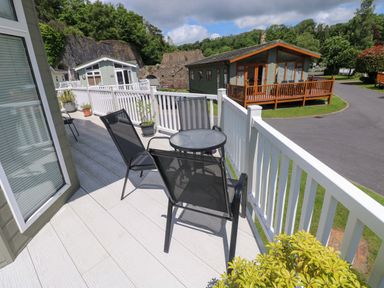 A outdoor patio with a table and chairs at Serenity in Kilgetty