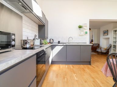 A modern kitchen with grey cabinets and a countertop with appliances and a pot at Long View in Southwold