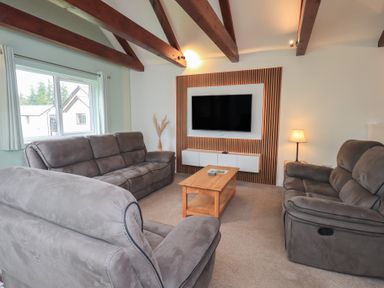 A living room with a sofa and a television at Whitbarrow 24 in Penruddock