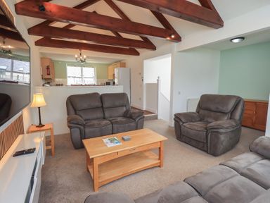 A living room with a sofa and armchairs at Whitbarrow 24 in Penruddock