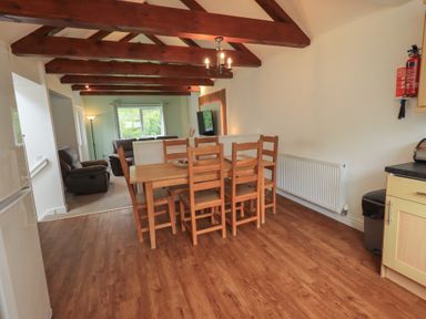 A dining room with a table and chairs at Whitbarrow 24 in Penruddock