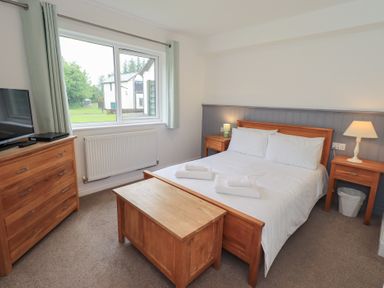 A bedroom with a bed and dresser at Whitbarrow 24 in Penruddock