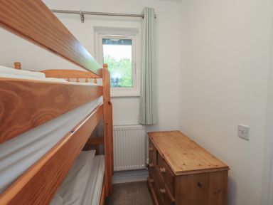 A bedroom with a bunk bed and a dresser at Whitbarrow 24 in Penruddock