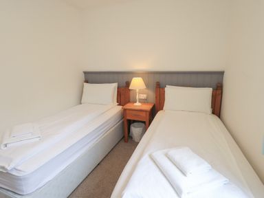 A bedroom with two beds and a nightstand at Whitbarrow 24 in Penruddock