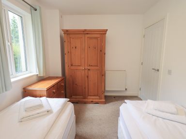 A bedroom with two beds and a wardrobe at Whitbarrow 24 in Penruddock