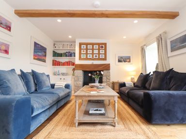 A living room with two sofas facing each other a wooden coffee table and bookshelves at The Riblows Cape Cornwall Bollowal near St Just