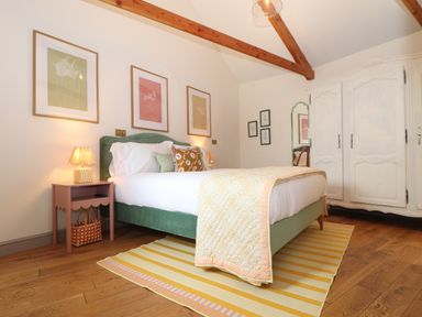A bedroom with a green bed frame and three framed pictures above the bed at The Riblows Cape Cornwall