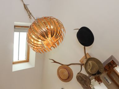 A ceiling light fixture and antler wall hooks with hats and a window at The Riblows Cape Cornwall Bollowal near St Just