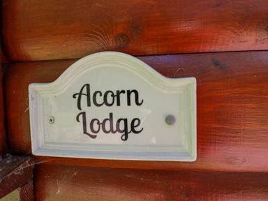 A sign reading Acorn Lodge mounted on a wooden wall at 64 Acorn Lodge Kenwick Park Louth