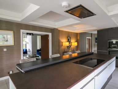 A modern kitchen with an island and a built in cooktop at Glamorgan House in Cardiff