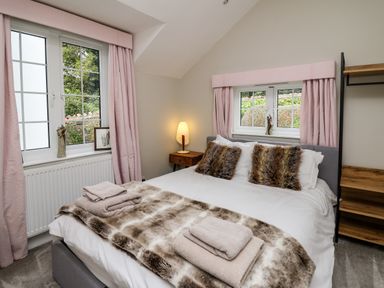 A bedroom with a double bed and pink curtains at Glamorgan House in Cardiff