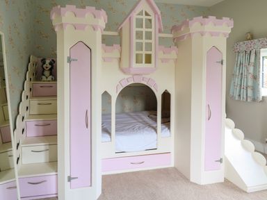 A child's bedroom with a castle-themed bed with pink and white details and a small slide at Glamorgan House in Cardiff
