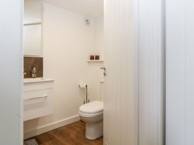 A bathroom with a toilet a white vanity and a mirror at Riverview @ 1 Brunel View Saltash