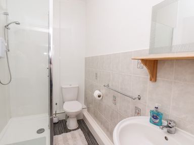A bathroom with a shower enclosure a toilet a sink and a mirror at 7 Beach View Beaconsfield House Bridlington