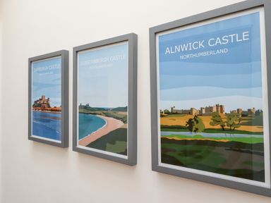Three framed posters of castles on a wall at 1 Orchard Cottages in Dunstan near Craster
