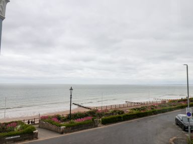 A coastal road with a pavement garden and lampposts overlooking a beach and sea at 4 Beach View Beaconsfield House in Bridlington