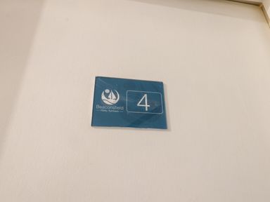 A wall sign with the number 4 and Beaconsfield Holiday Apartments logo at 4 Beach View @ Beaconsfield House in Bridlington