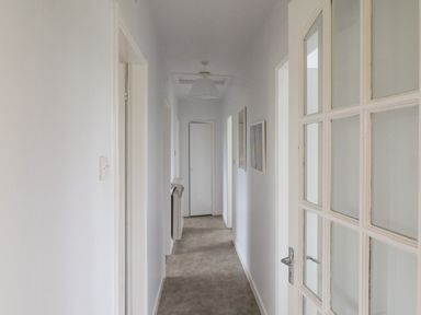 A hallway with white walls and ceiling light at Meeligolleen in Coill Tra
