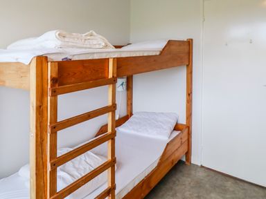 A bedroom with wooden bunk beds and white bedding at Meeligolleen in Coill Tra