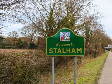 A green welcome sign for Stalham by a roadside with trees and bushes at The Mill Stones in Stalham
