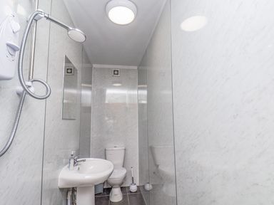 A bathroom with a showerhead sink toilet and mirror at Ocean Wave in Bridlington