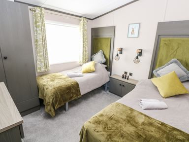 A bedroom with two single beds and green blankets at Beechwood Lodge Hasguard Cross near Broad Haven
