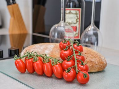 A kitchen counter with a loaf of bread cherry tomatoes two wine glasses and a bottle of wine at 4 Seaview @ Bridlington Bay in Bridlington