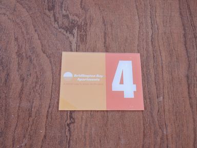 A sign with the number 4 and Bridlington Bay Apartments logo on a wooden surface at 4 Seaview @ Bridlington Bay in Bridlington