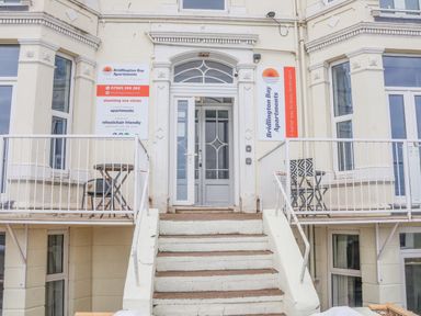 Entrance with stairs leading up to a door flanked by balconies with tables and chairs at 4 Seaview at Bridlington Bay in Bridlington