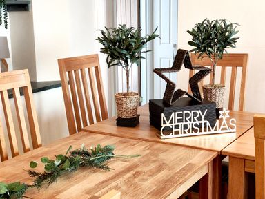 A dining table with potted plants and a Christmas decoration at The Paddock in Keswick
