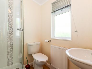 A bathroom with a toilet shower and sink at Nutkins Lodge Beckside 5 Limefitt Park near Windermere