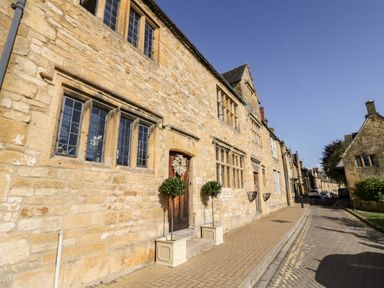 A street with stone buildings and windows along a sidewalk at The Old Stables in Chipping Campden