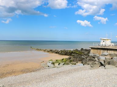 A rocky beach with a small building on a concrete platform by the sea at The Studio in Sheringham