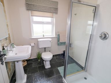 A bathroom with a pedestal sink toilet shower and window at The Haven in Falcarragh County Donegal