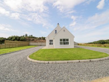 A house with a triangular roof surrounded by a gravel driveway and green grass at The Haven in Falcarragh County Donegal