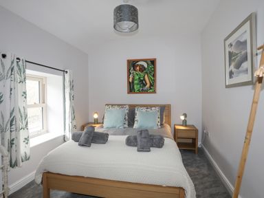 A bedroom with bed pillows and folded towels on the bed at Glyn Awel in Nant Gwynant near Beddgelert